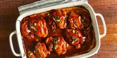 a casserole dish filled with meat covered in sauce and garnished with green onions