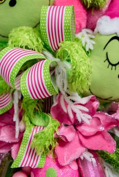 a pile of stuffed animals sitting next to each other on top of pink and green ribbons