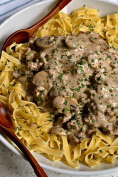 a white bowl filled with pasta covered in gravy