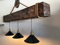 three lights are hanging from a wooden beam