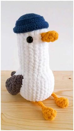 a crocheted bird with a blue hat on it's head and legs