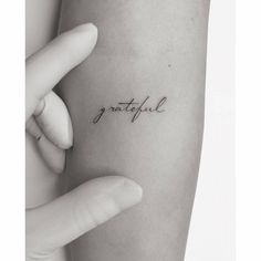 a woman's arm with the word grateful tattooed on it