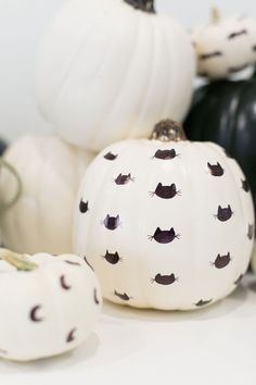 white pumpkins with black cats painted on them