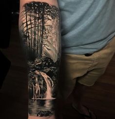 a man's arm with an image of a waterfall and horses in the water