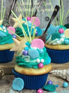 three cupcakes decorated with sea shells and seashells