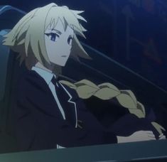 an anime character with blonde hair and blue eyes sitting in front of a computer screen