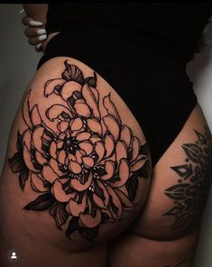 a woman's thigh with a flower tattoo on it