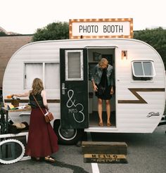 two people standing in the doorway of a trailer