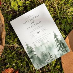 the wedding card is laying on the ground next to some flowers and a bird's foot