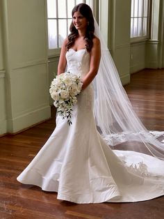 a woman in a wedding dress holding a bouquet