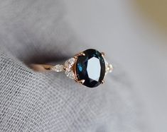 a close up view of a ring with an oval blue stone and diamonds on it