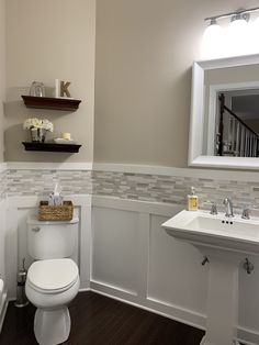 a white toilet sitting in a bathroom next to a sink