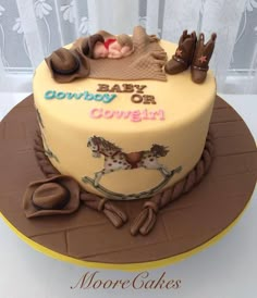 a baby is laying in a cowboy hat on top of a horse themed birthday cake