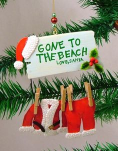 christmas ornaments hanging from a tree with santa's hats and stockings attached to them