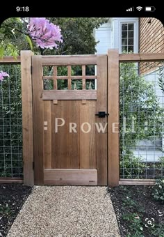 a wooden gate with the word rowe written on it in front of a garden area