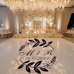 the floor is decorated with flowers and greenery for an elegant wedding reception in black and white