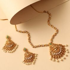 Description This traditional classic necklace Mishi antique necklace set is a classic statement design to pair with any traditional attire. Featuring lakshmi motif in the center studded with kempu stones & gold ball drops, this all-around necklace gives shine to the overall look. Pair it with any simple or heavy ethnic attire to complete the Indian look. Details & Specifications: Materials used: Brass Alloy with Antique Gold Plating Weight - Necklace: 30 gms, Earrings: 16 gms Length - Necklace: Gold Kundan Necklace For Festive Anarkali Style, 30 Gms Gold Necklace, Diwali Temple Necklace With Stone Work, Gold Kundan Necklace With Meenakari, Navratri Temple Jewelry Necklace With Stone Work, 30 Gms Gold Necklace Set, Antique Necklace Set, Indian Look, Ball Drop