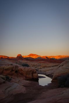 sunlight casts dramatic shadows on the red rocks of valley of fire state park in nevada at sunset, photographed by jamie bannon photography.