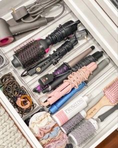 the drawer is filled with many different types of hair brushes