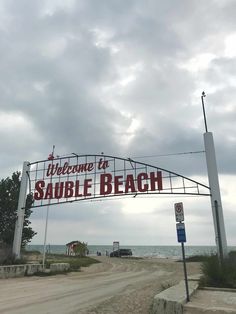 a sign that says welcome to sauble beach on the side of a road