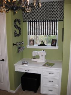 a sewing machine sitting on top of a white desk in a room with green walls