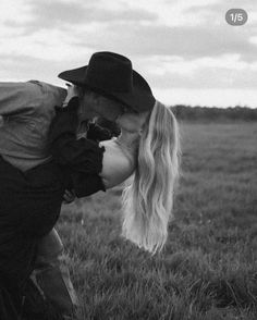 a man kissing a woman on the nose in a field