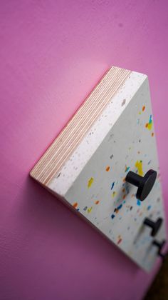 a pink wall with a white board mounted to it's side and black handles