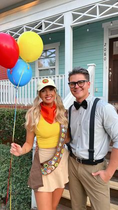 a man and woman posing for a photo with balloons in front of a house on a sunny day