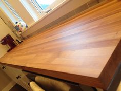 a wooden counter top in a kitchen next to a window