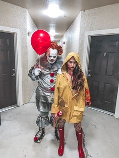 two people in costumes are walking down the hallway with balloons on their heads and one is holding a red balloon