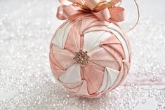 a pink and white ornament with bows on it