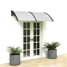 two potted plants sitting next to each other in front of a white door with an awning over it