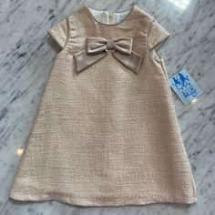 New Girls Luli & Me Party Dress. Its A Shimmery Blush Gold Fabric With A Cap Sleeve And Satin Bow In The Middle Of The Chest. It’s Fully Lined And It Zips Up The Back. There Are Matching Sister Styles. All Of My Items Are Brand New With All Tags Attached From The Manufacturer. Please Feel Free To Ask Any Questions Cream Party Dress With Bow, Elegant Pink Sleeveless Holiday Dress, Elegant Sleeveless Pink Holiday Dress, Pink A-line Dress With Bow, Elegant Pink Holiday Dress For Festive Occasions, Cute Beige Dress For Dress-up, Holiday Pink Dress With Bow, Beige Dress For Spring Dress-up Occasion, Beige Dress For Spring Dress-up