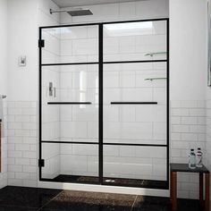 a bathroom with white tile and black glass shower doors