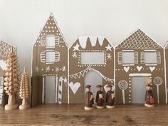 some wooden figurines sitting on top of a shelf next to gingerbread houses