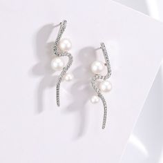 Elevate your style with our Elegant Curve 925 Silver & Freshwater Pearl Studs. Crafted with meticulous precision, each stud showcases a lustrous freshwater pearl, ranging from 4-7MM, perfectly round and virtually flawless. The curve of the 925 silver beautifully complements the pearl's natural radiance, creating a timeless piece that exudes sophistication and charm. Perfect for every occasion, these earrings are a testament to elegance and grace. Experience the allure of nature and craftsmanship Luxury Silver Pearl Chain Earrings, Luxury Silver Earrings With Pearl Chain, Formal Silver Pearl Chain Earrings, Silver Pearl Earrings With Sparkling Stones For Formal Occasions, Formal Silver Pearl Earrings With Sparkling Stones, Elegant Sparkling Pearl Earrings For Formal Occasions, Modern Silver Pearl Earrings For Formal Occasions, Baroque Pearls Necklace, Mother Of Pearl Earrings