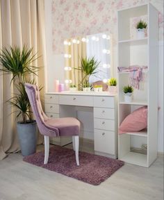 a pink chair sitting in front of a desk with a mirror and lights on it