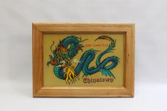 a framed painting with a blue dragon on it's face and the words chinatown written in chinese