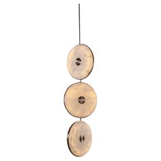 three discs hanging from a metal hook on a white background, with one disc spinning in the air