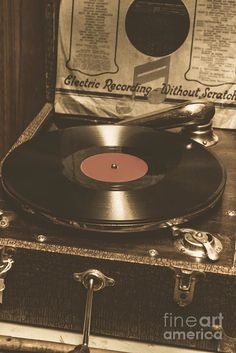 an old record player sitting on top of a suitcase