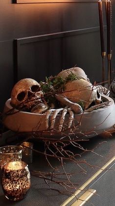 a table with candles, skulls and branches on it in front of a framed photograph