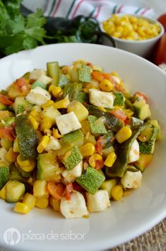 a white bowl filled with corn and vegetables