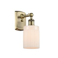 an antique brass finish wall light with frosted glass shade