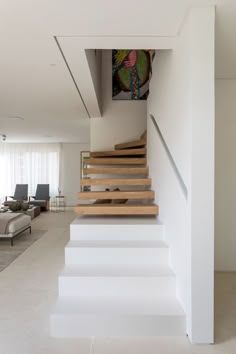 there is a staircase in the middle of this living room with white walls and flooring