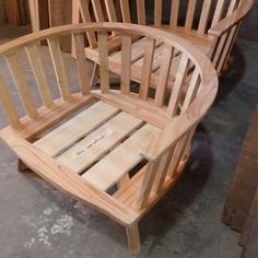 two wooden chairs sitting next to each other on top of a cement floor in a room