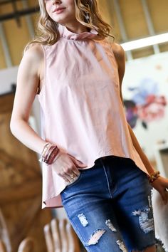 There’s no need to sacrifice style for comfort with this dreamy blush-hued blouse. Equal parts polished and playful, it features a ruffled tie neckline and flirty tie-back detail. The buttery soft fabric and flowy cut mean you’ll feel as fabulous as you look whether you’re powering through the workday or enjoying a night out. Pair it with sleek slacks or a pencil skirt for the office, then switch to distressed denim and heels for happy hour—this top is a chameleon that adapts to any occasion. Wi Rachel Clark, Take The High Road, High Road, Denim Day, Pink Ruffle, Ruffle Top, The High, Dusty Pink, Distressed Denim