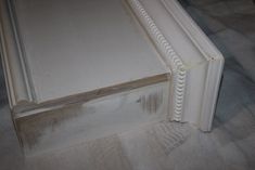 the bottom part of a bed frame with white paint on it