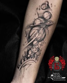 a black and white photo of a tattoo on the arm, with saturn in the background