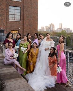 a group of women standing next to each other on top of a wooden floored walkway