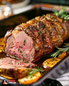 a roasting pan with meat, potatoes and herbs on it is ready to be cooked